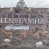 Focus on the Family sign with graffiti reading "their blood is on your hands" and "five lives taken"