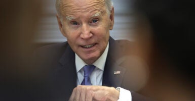 President Joe Biden gestures in a suit with an American flag pin