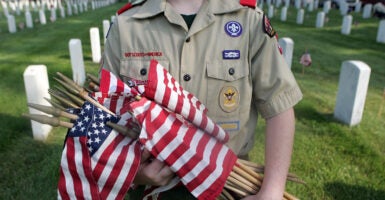 A Boy Scout holds flags to be placed on each grave at Zachary Taylor National Cemetery May 26, 2007 in Louisville, Kentucky.