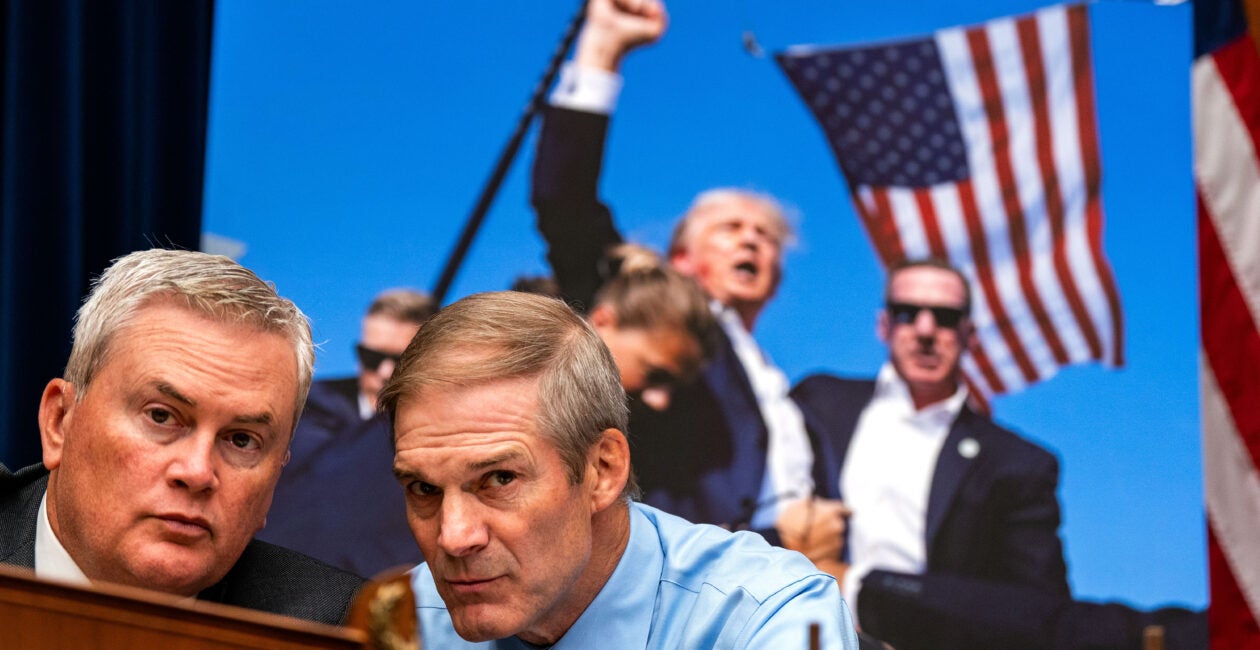 Jim Jordan and James Comer whispering to one another.