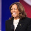 Kamala Harris in a white shirt and a black sport coat laughs