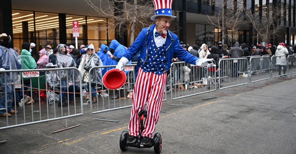 A supporter of Donald Trump, dressed as Uncle Sam and riding a Segway-type scooter, waits outside Capital One Arena in Washington, D.C., for a MAGA victory rally.