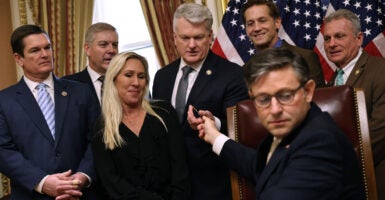 House Speaker Mike Johnson hands the pen he used to sign the Laken Riley Act to Rep. Mike Collins of Georgia, as other members of Georgia's congressional delegation look on.