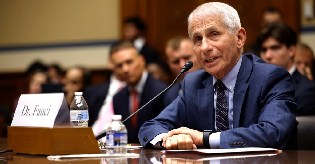 Anthony Fauci sits at a table with a microphone in front of him as he testifies.