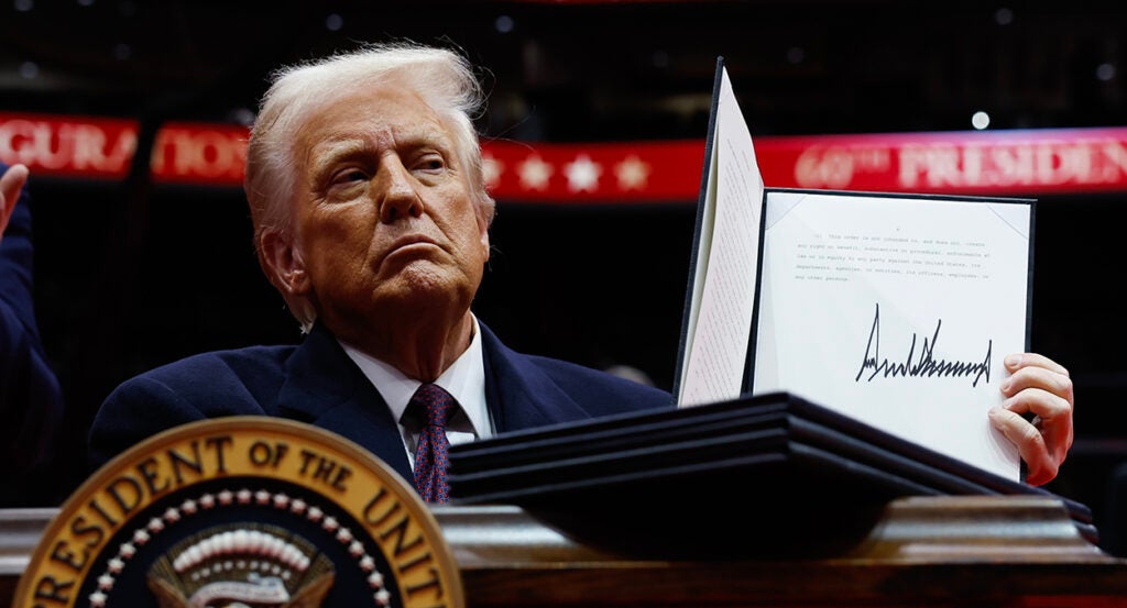 Donald Trump holds up an executive order he just signed.