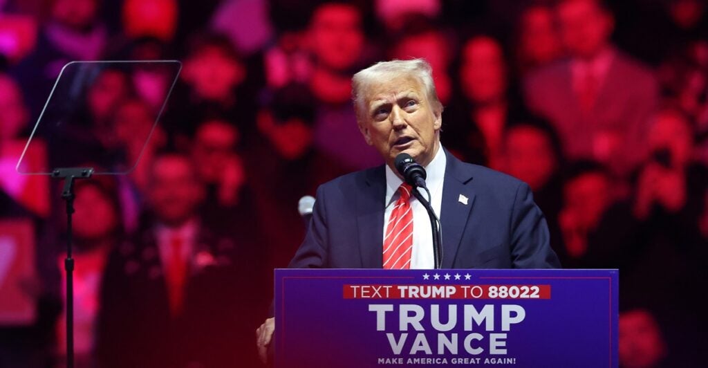 Donald Trump stands at a podium and speaks.