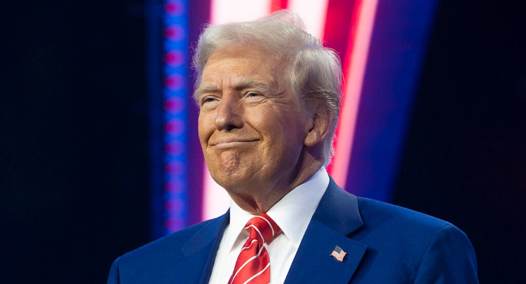 Donald Trump smiles in a blue suit