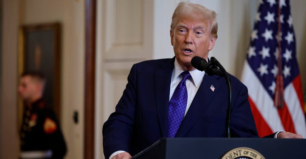 Donald Trump in a suit in front of an American flag