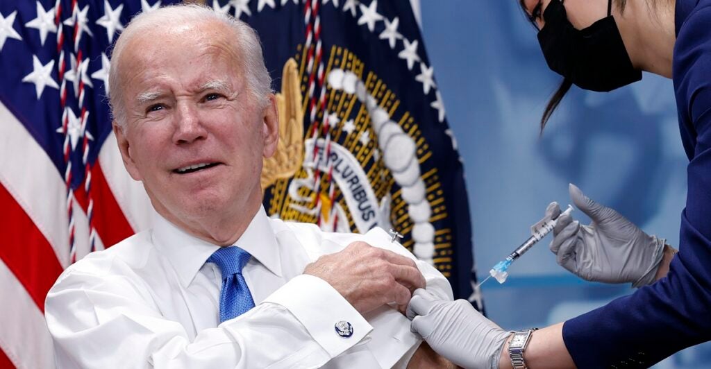 Joe Biden grimaces as he gets a shot of the COVID-19 vaccine.
