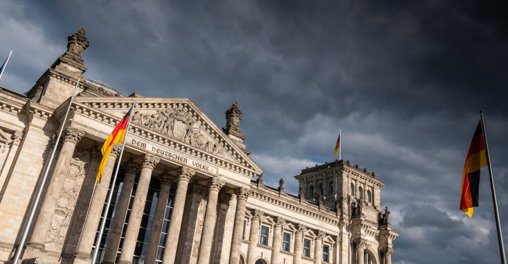 Germany's Parliament building with dark clouds in the background.