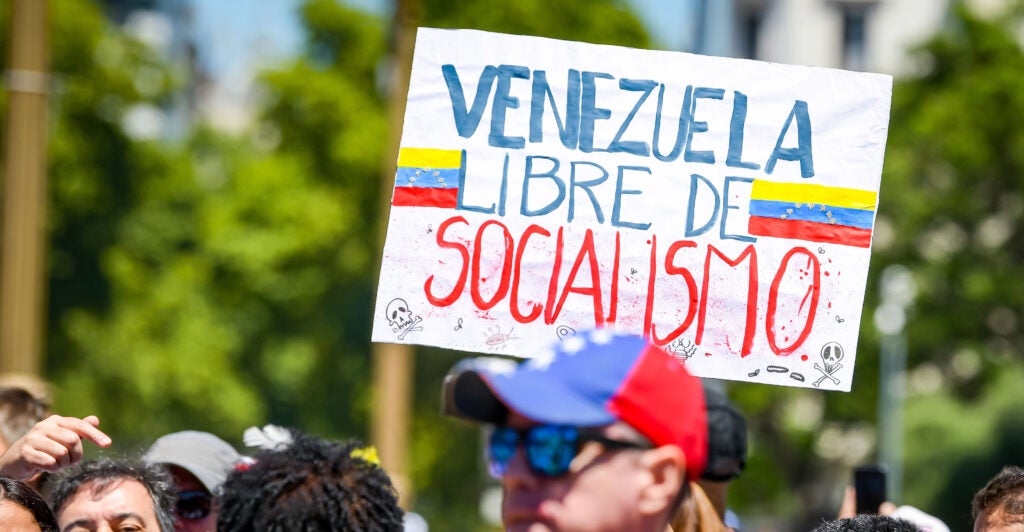 A sign in protest reads, "Venezuela Libre de Socialismo."