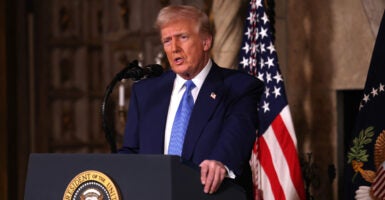 President Donald Trump speaks while standing at a podium.