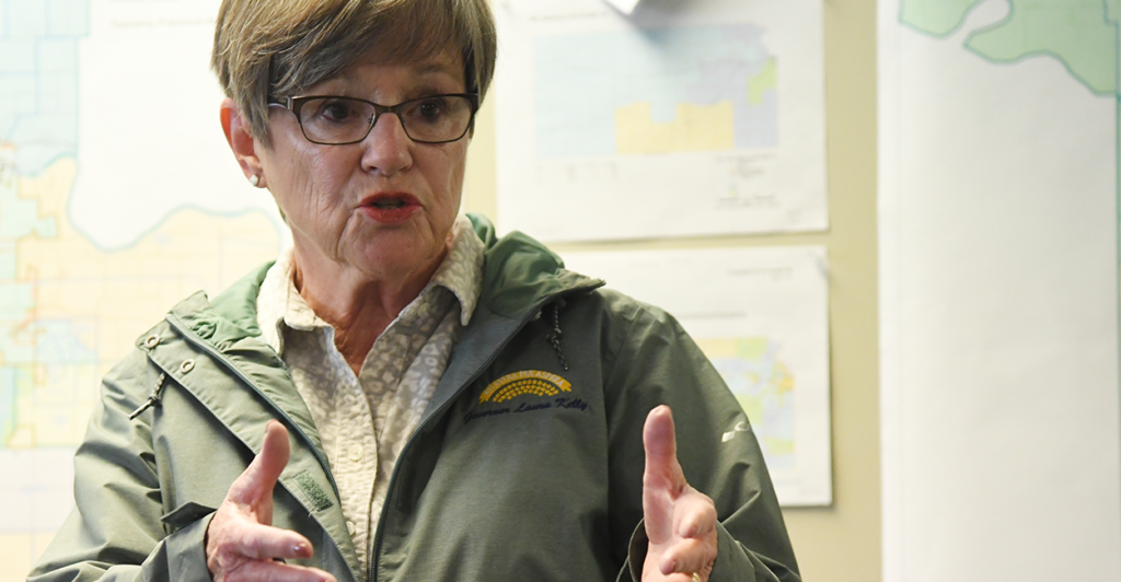Governor Laura Kelly gestures while speaking to a group of supporters.