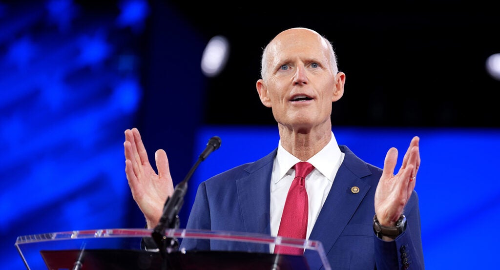 Rick Scott in a blue suit with a red tie
