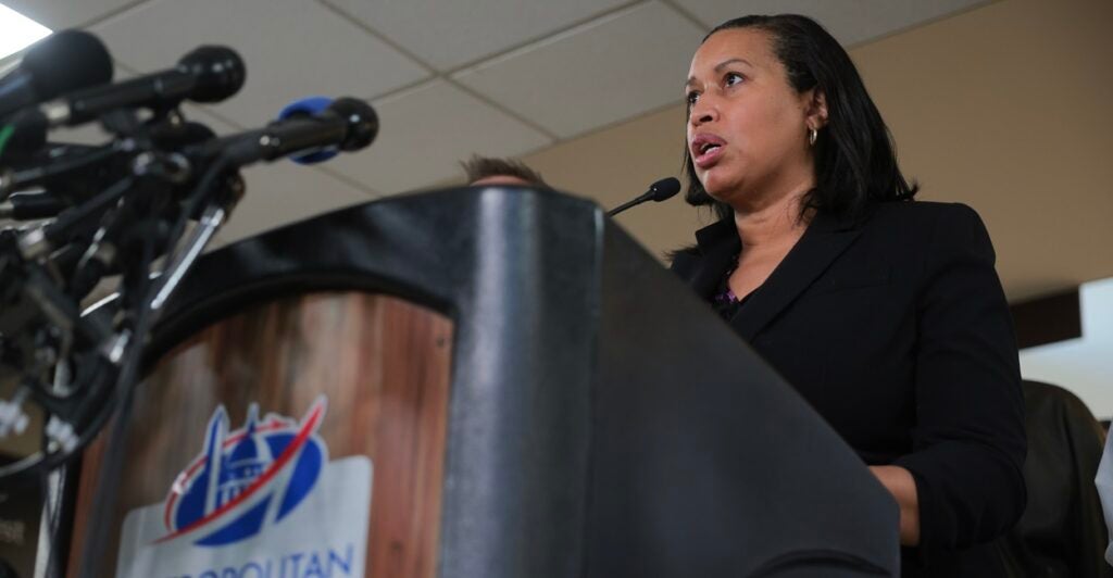 Muriel Bowser stands at a podium and speaks as she looks out in front of her.