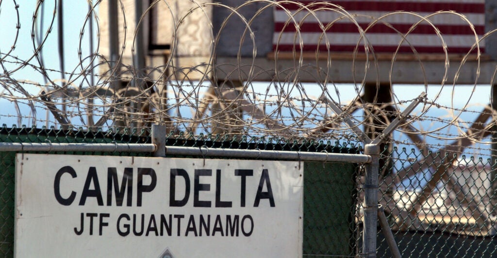 Barbed wire fencing and a guard tower at the U.S. military prison in Guantanamo Bay, Cuba