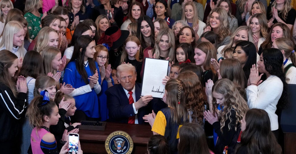 President Donald Trump, surrounded by female athletes, signs the “No Men in Women’s Sports” executive order at the White House on Feb. 5.