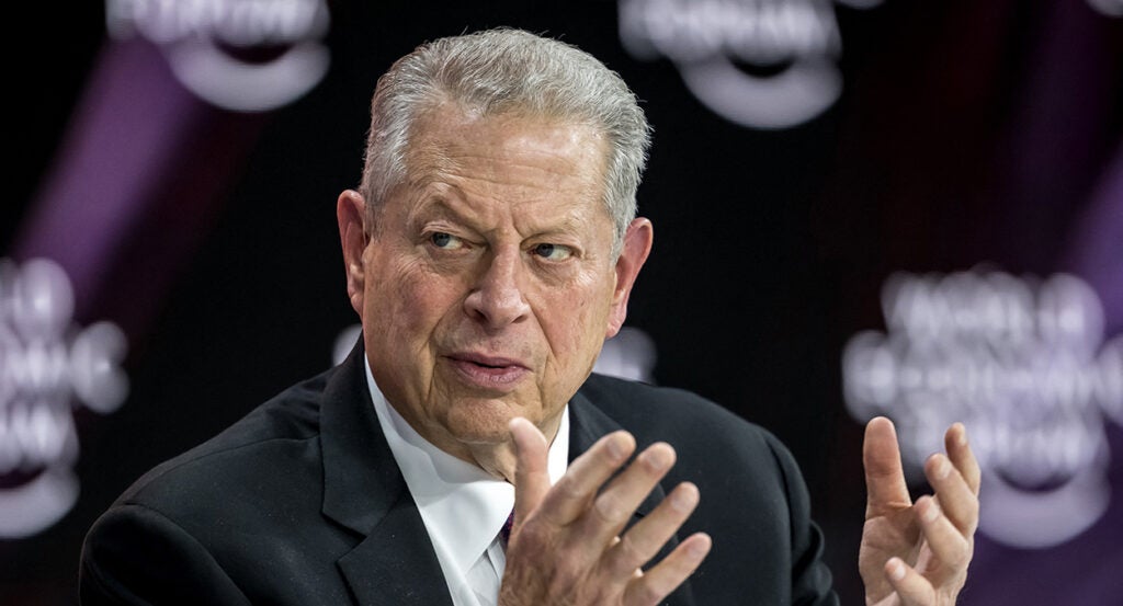 Al Bore in a black suit gestures