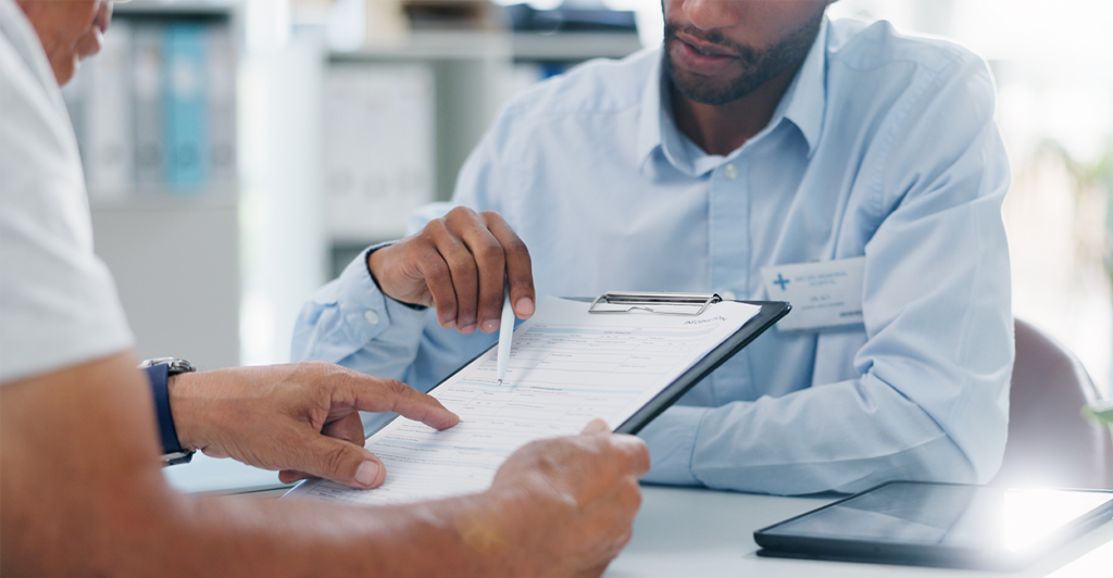 Doctor helps patient fill out paperwork.