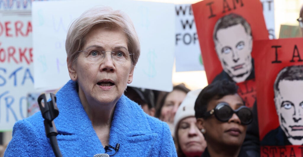 Elizabeth Warren wears a light blue sweate.