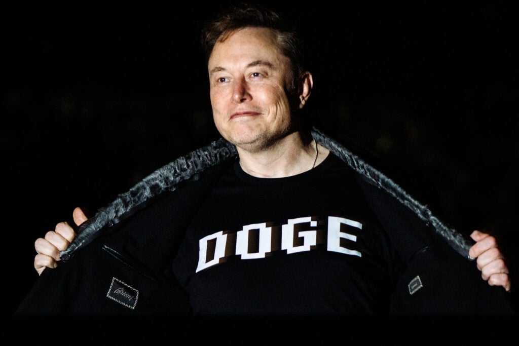 Elon Musk wears a garment sporting the acronym "DOGE" for the Department of Government Efficiency