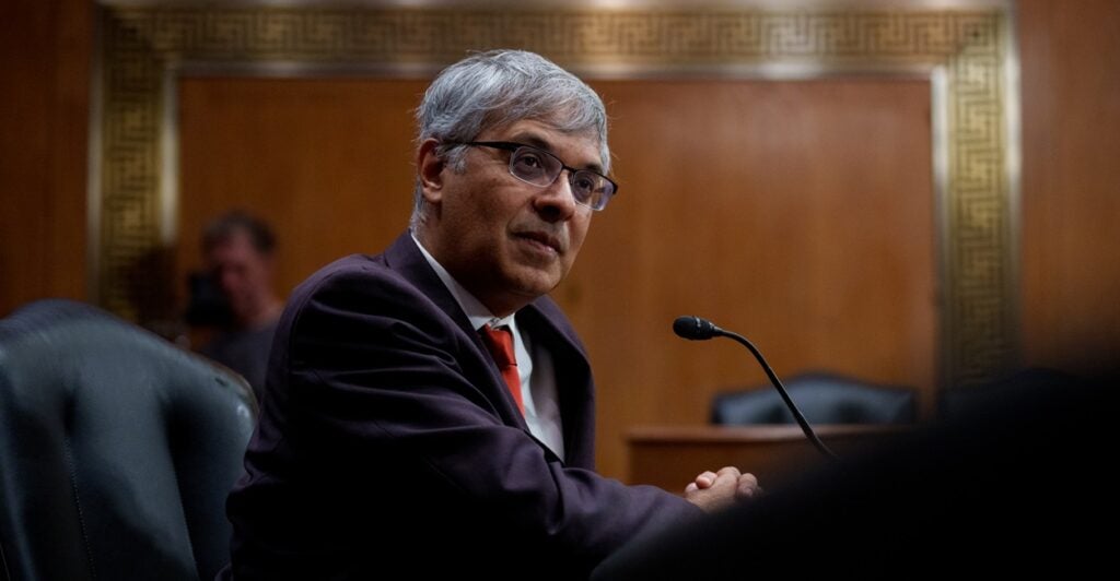 Jayanta Bhattacharya looks to his right while sitting down as he testifies before a hearing.