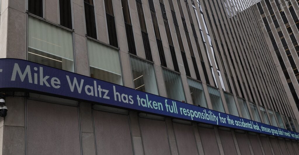 A Fox News ticker tape shows a headline about the leak in a group chat involving the Trump administration.