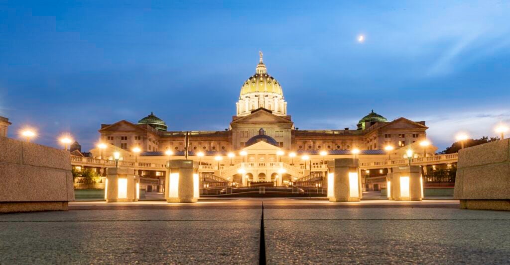 The Pennsylvania state capital is lit up at dusk.