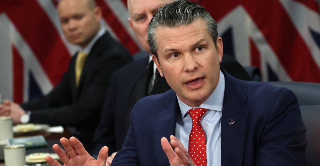 Pete Hegseth talks while turning to his left and using his hands to emphasize a point.
