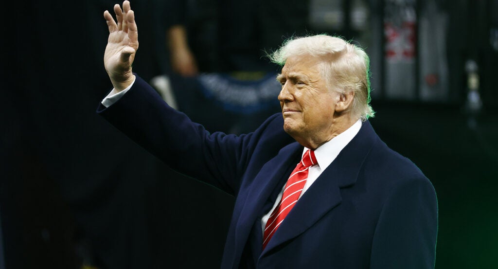 Donald Trump in a suit waves