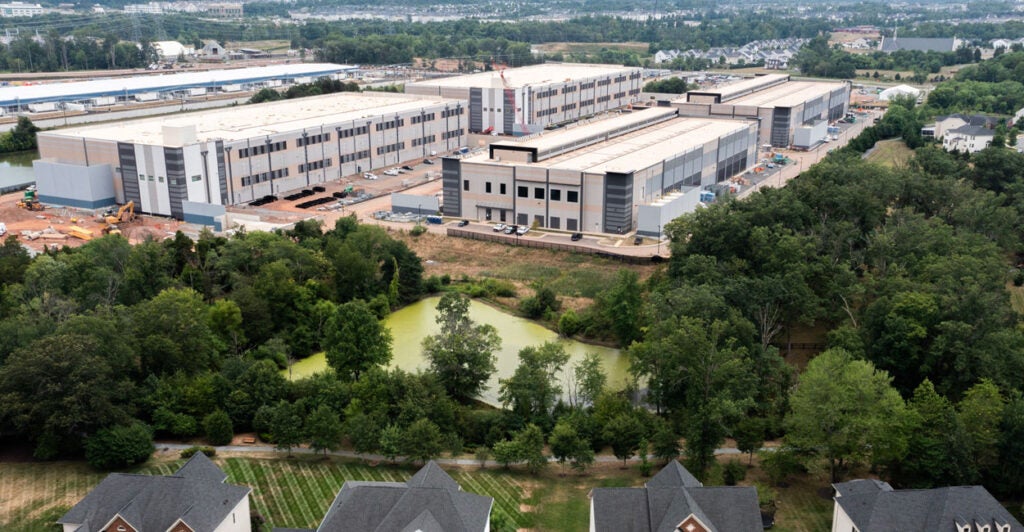 An Amazon Web Services data center is shown situated near single-family homes