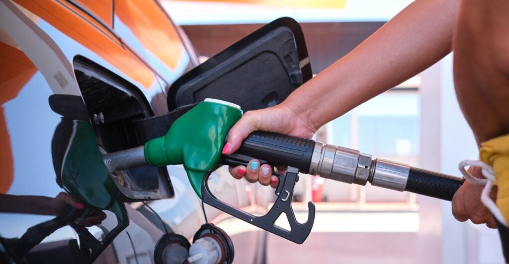 A person fills up their car with a gas pump.