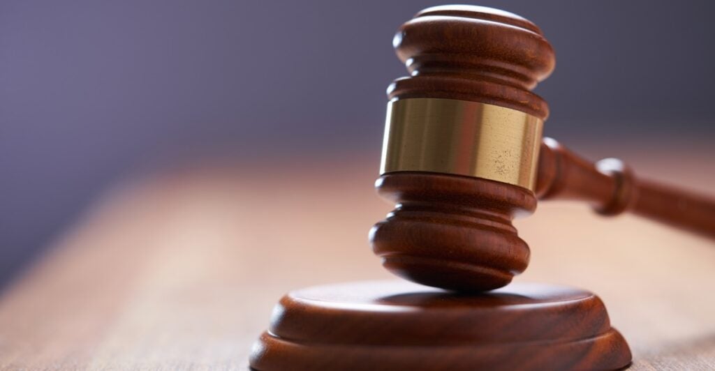 A gavel is displayed on a wooden table.