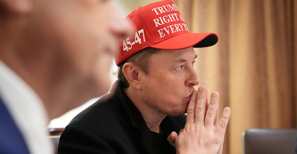 Wearing a red pro-Trump baseball-style cap, Elon Musk attends a Cabinet meeting on Monday.