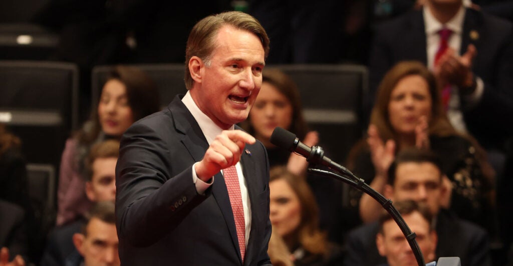 Virginia Governor Glenn Youngkin speaks at a podium and gestures by pointing his finger