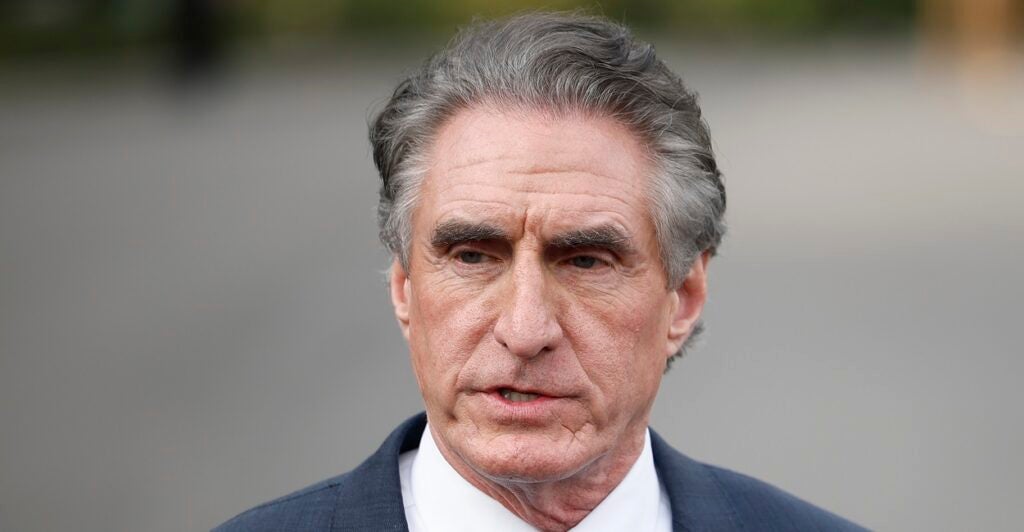 Doug Burgum is standing and stares ahead as he talks to reporters at the White House.