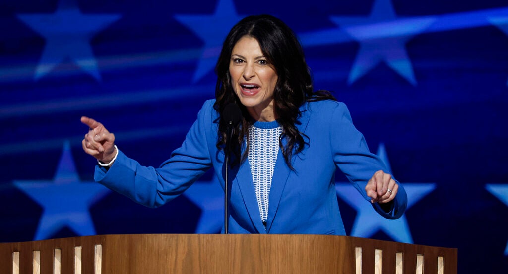 Michigan AG Dana Nessel in A blue suit on stage with a microphone