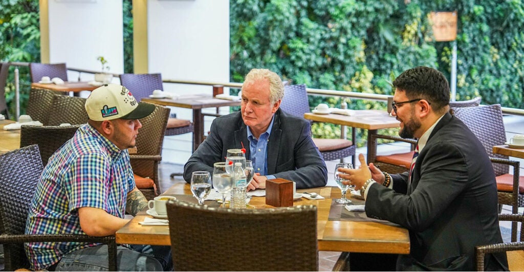 Kilmar Armando Abrego Garcia meets with Sen. Chris Van Hollen, D-Md., and his attorney sit around a table and talk.