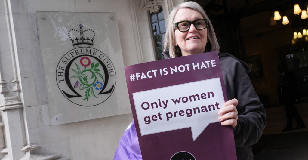 A women's rights activist makes her opposition to transgenderism known outside the U.K. Supreme Court in London with a sign that reads "#Fact is not hate: Only women get pregnant."