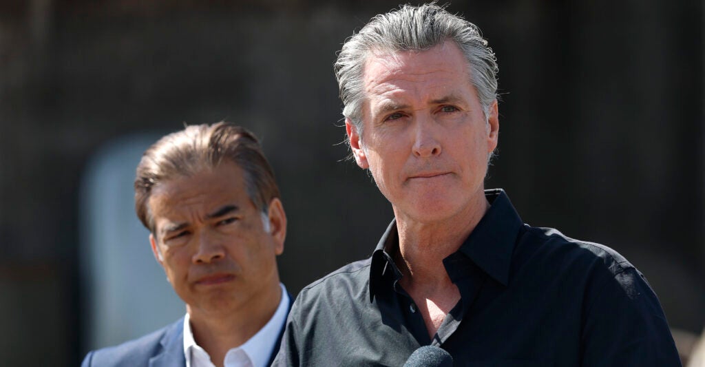 Gavin Newsome stands wearing a black dress shirt.