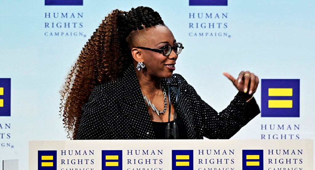 Human Rights Campaign President Kelley Robinson gestures while in a black suit coat with