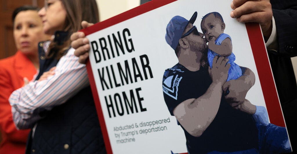 A sign with a photo of Kilmar Abrego Garcia reads "Bring Kilmar Home."