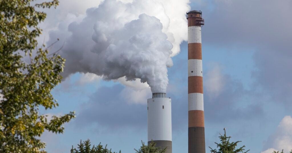 A smokestack from a coal-fired plant in Pennsylvania is seen through the trees.
