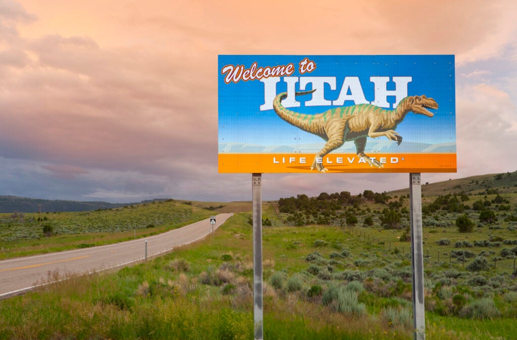 A sign by the side of a remote highway welcomes people to the state of Utah.