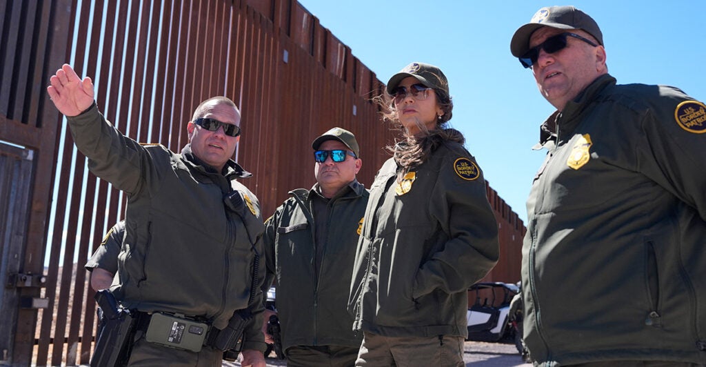 Homeland Security Secretary Kristi Noem listens to three border agents during a tour along the Nogales border wall at the Mariposa Port of Entry in Nogales, Arizona, March 15, 2025.