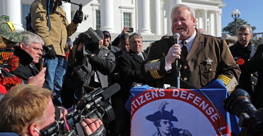 Culpeper County, Virginia, Sheriff Scott Jenkins, wearing his brown Sheriff's uniform and standing at a podium outside of the Virginia capitol building and surrounded by media, speaks during a gun rights rally