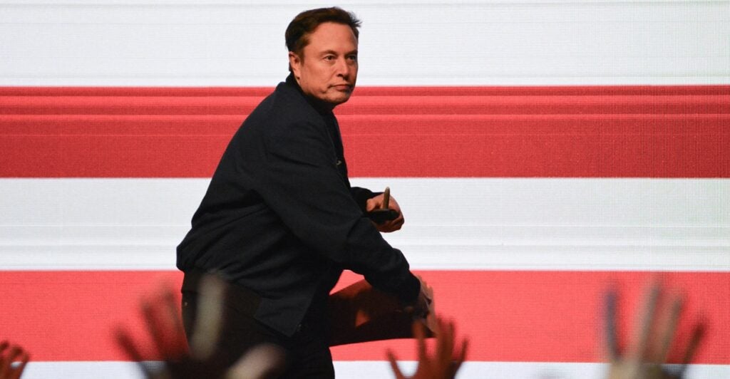 Elon Musk throws a signed cheesehead hat he was wearing into the crowd.