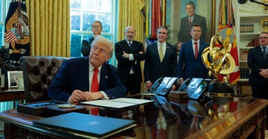 With Cabinet officials watching on, President Donald Trump signs an executive order in the Oval Office eliminating the regulations on shower heads.