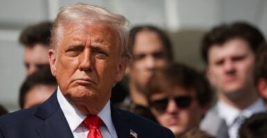 Donald Trump stands at a press conference and looks straight ahead.