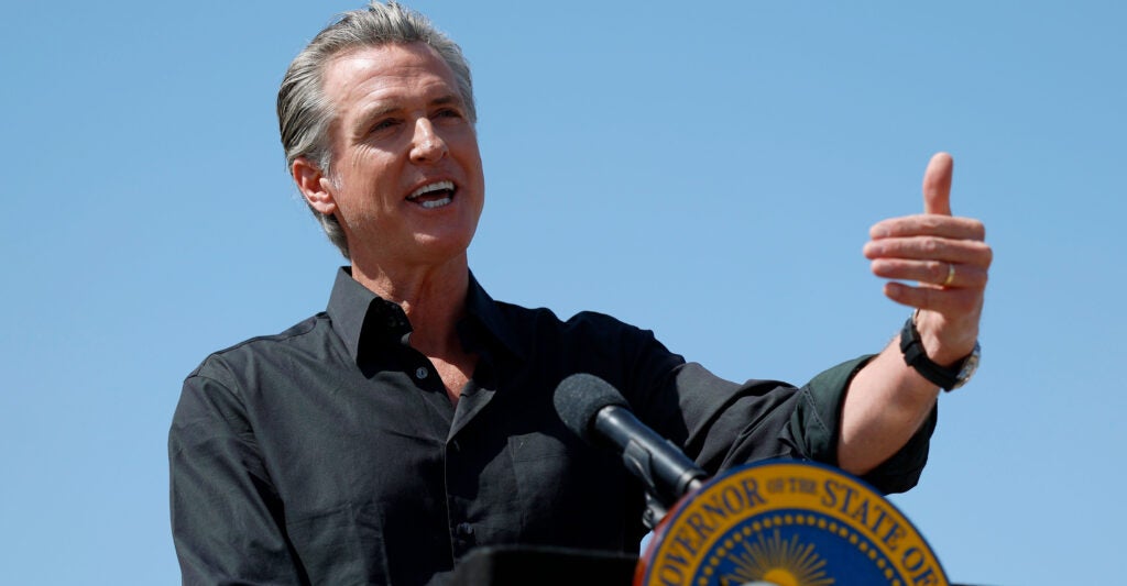 California Gov. Gavin Newsom speaks from behind a lectern adorned with the state seal at a news conference on April 16 in Ceres, California.